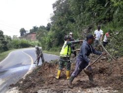 Anggota Bhabinsa Gotong Royong Bersihkan Material Bekas Longsor
